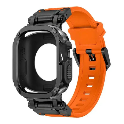 orange apple watch band and black case, laid down on a black table next to air pods and a black notebook