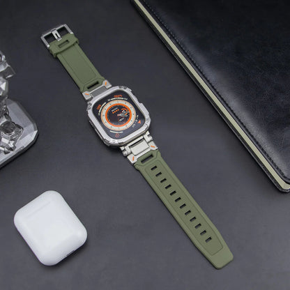 army green apple watch band and grey rugged case, laid down on a black table next to air pods and a black notebook
