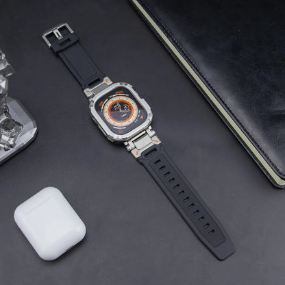 black apple watch band and grey rugged case, laid down on a black table next to air pods and a black notebook