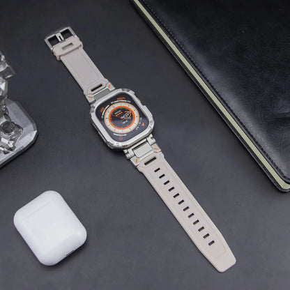 white apple watch band and grey case, laid down on a black table next to air pods and a black notebook